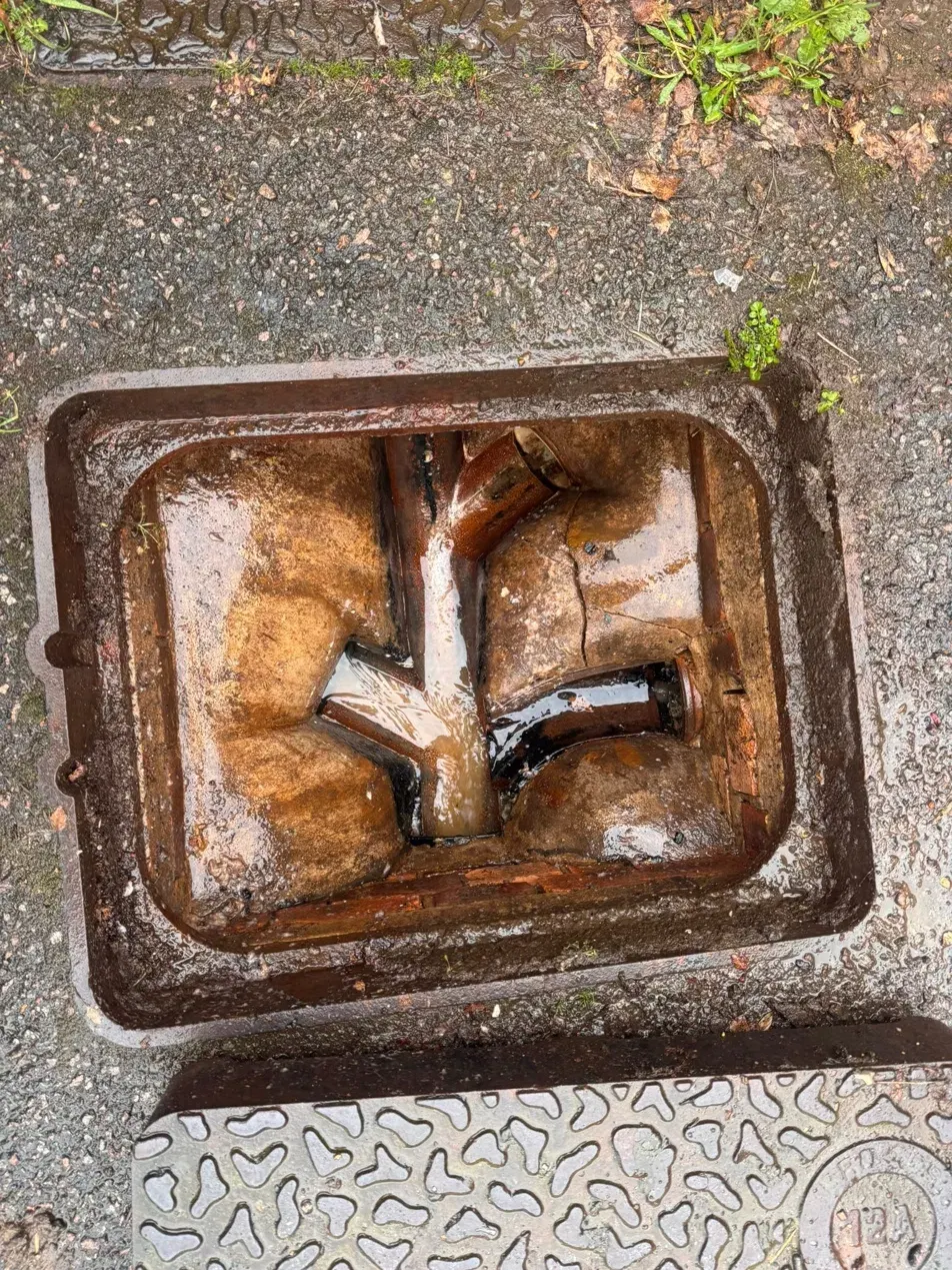 After clearing, the same roadside gully chamber cleaned out to reveal the open channels and cracked clay sides.